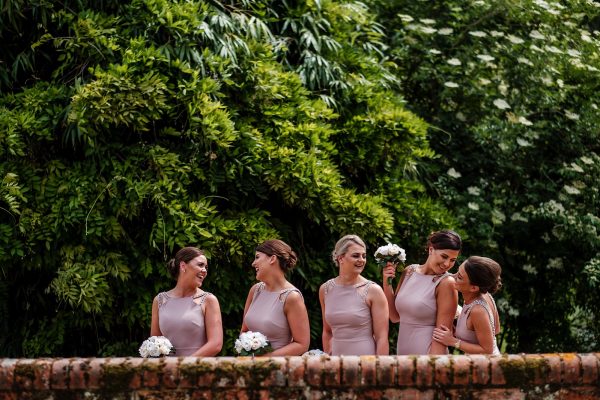 Bridesmaids talking and laughing with each other before the start of the wedding